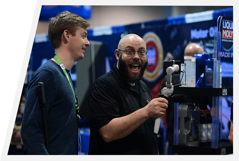 VISION KC attendees happily interacting with industry tool at expo